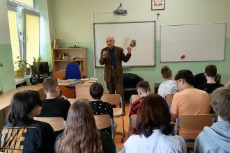 Profesor Ryszard Waksmund pokazuje uczniom tomik wierszy Marii Konopnickiej
